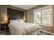 Relaxing bedroom with a wooden accent wall, window view, and soft lighting to create a cozy atmosphere at 11823 E 200 S, Zionsville, IN 46077