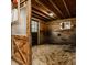 Cozy horse stall featuring wood paneling, a window, and bedding at 11823 E 200 S, Zionsville, IN 46077