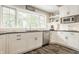 Corner of a sunlit kitchen with white cabinets, dark countertops, and stainless steel appliances at 11823 E 200 S, Zionsville, IN 46077
