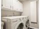 Efficient laundry room equipped with modern, white appliances and ample cabinet space for storage at 11823 E 200 S, Zionsville, IN 46077