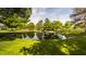 Scenic pond surrounded by mature trees and lush green grass, offering a serene outdoor space at 11823 E 200 S, Zionsville, IN 46077