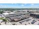 Aerial view of commercial buildings surrounded by parking lots and lush green trees on a partly cloudy day at 1205 N Temple Ave, Indianapolis, IN 46201
