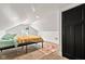 Bright attic bedroom featuring a sloped ceiling, light walls, and a black door leading to ample closet space at 1205 N Temple Ave, Indianapolis, IN 46201