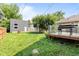 Grassy backyard featuring a wooden deck, a shed, a privacy fence and a grill at 1205 N Temple Ave, Indianapolis, IN 46201