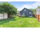Large backyard featuring a deck, lawn, mature trees and a small storage shed behind a privacy fence at 1205 N Temple Ave, Indianapolis, IN 46201