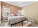 Inviting bedroom with light walls, large window, and bed featuring a colorful quilt and pink decorative pillow at 1205 N Temple Ave, Indianapolis, IN 46201