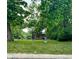 A grassy outdoor area filled with people, trees, and greenery on a partly cloudy day in a public space at 1205 N Temple Ave, Indianapolis, IN 46201