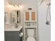 Bright bathroom featuring a walk-in shower, gray vanity, and a decorative cabinet for storage at 1219 Citation W Cir, Lebanon, IN 46052