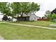 Well-maintained front yard featuring a large tree, green grass, and a sidewalk at 1219 Citation W Cir, Lebanon, IN 46052