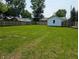 A large grassy backyard surrounded by a wooden fence, with a peek at a garage at 1359 S Mulberry St, Martinsville, IN 46151