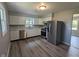Updated kitchen features stainless steel appliances, white cabinets, and modern flooring at 1359 S Mulberry St, Martinsville, IN 46151