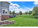 Large grassy backyard with a deck and a black metal fence surrounding the perimeter at 14458 Smickle Ln, Carmel, IN 46033