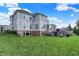 Backyard with green lawn, deck and fencing under a blue sky at 14458 Smickle Ln, Carmel, IN 46033