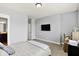 Bright bedroom featuring light gray walls and modern amenities like a wall-mounted TV and a dedicated workspace at 14458 Smickle Ln, Carmel, IN 46033