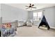 Bedroom with a crib, play tent, a dresser with mirror doors, and a cozy chair with lots of natural light at 14458 Smickle Ln, Carmel, IN 46033