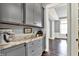 Butler's pantry features gray cabinets with marble countertops, and herringbone wood floors into the next room at 14458 Smickle Ln, Carmel, IN 46033
