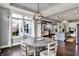 Charming dining area showcasing dark wood floors, large windows and seamless transition into the kitchen and living area at 14458 Smickle Ln, Carmel, IN 46033