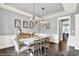 Dining room with wainscoting, hanging light fixtures, dark floors, and traditional furniture at 14458 Smickle Ln, Carmel, IN 46033