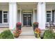 Inviting front porch with decorative columns, seasonal flowers, and double doors at 14458 Smickle Ln, Carmel, IN 46033