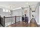 Upstairs landing featuring a coffee bar with wine fridge, dark wood floors, and stylish caged chandelier at 14458 Smickle Ln, Carmel, IN 46033