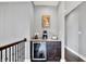 Upstairs landing coffee bar with wine fridge, light countertop, and a painting of a floral still-life at 14458 Smickle Ln, Carmel, IN 46033