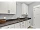 Clean laundry room with white cabinetry, countertops, stainless steel sink, and sleek hardware at 14458 Smickle Ln, Carmel, IN 46033