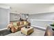Upstairs living room with brown couch, ottoman, dark wood floors, caged chandelier, and coffee bar nearby at 14458 Smickle Ln, Carmel, IN 46033