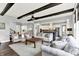 Open-concept living room showcasing hardwood floors, wood beams, and seamless flow to kitchen at 14458 Smickle Ln, Carmel, IN 46033