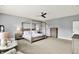 Bright main bedroom with a four poster bed, sitting area, light gray walls and plush neutral carpet at 14458 Smickle Ln, Carmel, IN 46033