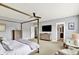Spacious main bedroom with ceiling fan, four poster bed, plush carpet, and doorway to the en suite bath at 14458 Smickle Ln, Carmel, IN 46033