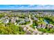 Aerial view of a tree-lined neighborhood with lush green lawns and a serene pond at 14458 Smickle Ln, Carmel, IN 46033