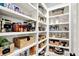Pantry with white shelving stocked with food items and wicker baskets for optimal storage and organization at 14458 Smickle Ln, Carmel, IN 46033