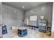 Bright playroom features gray wainscoting, palm leaf print flooring, and white board for homeschooling and activities at 14458 Smickle Ln, Carmel, IN 46033