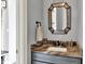 Stylish powder room featuring a stone countertop, vanity with storage, and a decorative mirror at 14458 Smickle Ln, Carmel, IN 46033