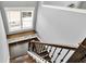 A staircase with wood steps and wrought iron spindles ascends to a landing with window bench and storage at 14458 Smickle Ln, Carmel, IN 46033