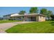 Charming single-story home with a stone facade, attached carport, and manicured front lawn at 1460 W Mckay Rd, Shelbyville, IN 46176