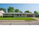 Charming single-story home featuring stone facade, well-manicured lawn, mature trees and attached carport at 1460 W Mckay Rd, Shelbyville, IN 46176