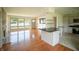 Bright living room features hardwood floors, large windows, and a fireplace, seamlessly connecting to the kitchen with a breakfast bar at 1460 W Mckay Rd, Shelbyville, IN 46176