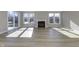 Sunlit living room boasts hardwood floors and a fireplace with large windows, a perfect place to relax at 16774 Imperial Ct, Fishers, IN 46040