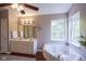 A spacious bathroom features double vanity sinks and a soaking tub near bright windows at 17635 Willow Creek Way, Westfield, IN 46074
