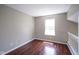 A cozy bedroom with warm hardwood floors and a bright window offering natural light at 17635 Willow Creek Way, Westfield, IN 46074