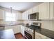 This kitchen features white cabinets, stainless appliances, hardwood floors, and an island with seating at 17635 Willow Creek Way, Westfield, IN 46074