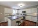 This kitchen features white cabinets, a large island with seating, stainless appliances, and hardwood floors at 17635 Willow Creek Way, Westfield, IN 46074
