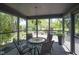 Relaxing screened-in porch with a table, chairs, and chandelier overlooking the manicured backyard at 17635 Willow Creek Way, Westfield, IN 46074