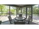 Inviting screened-in porch with wicker furniture, perfect for outdoor dining and relaxation at 17635 Willow Creek Way, Westfield, IN 46074