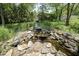 Relaxing backyard water feature with beautiful rockwork and lush garden landscaping at 17635 Willow Creek Way, Westfield, IN 46074