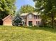 Beautiful brick home with a lush green lawn, mature trees, and attached garage at 2002 Grey Fox Ct, Martinsville, IN 46151