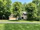 Beautiful brick home with a well-manicured lawn, mature trees, and an attached garage at 2002 Grey Fox Ct, Martinsville, IN 46151