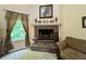 Inviting living room features a brick fireplace and window with decorative curtains at 2002 Grey Fox Ct, Martinsville, IN 46151