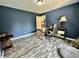 Office space featuring wood-look floors, a light wood desk, and blue walls at 2002 Grey Fox Ct, Martinsville, IN 46151